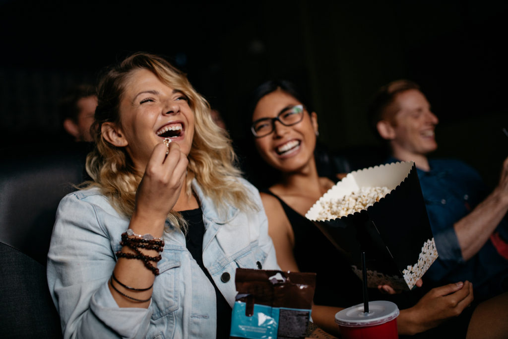 Young women friends laughing at a movie