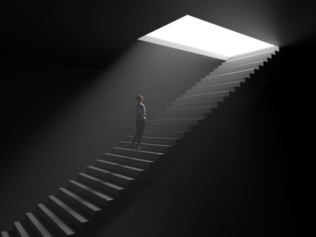 Person climbing stairs toward the light