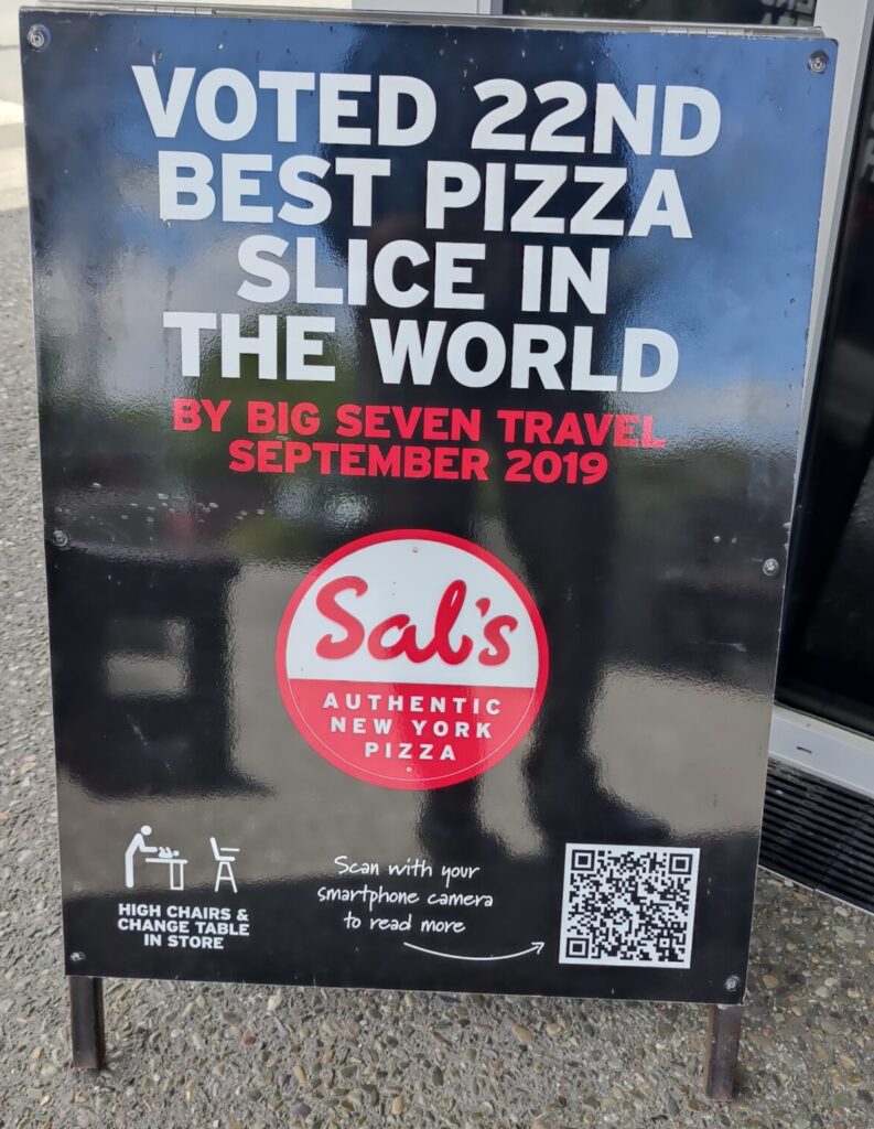 Sign states the pizza shop has the 22nd best pizza in the world