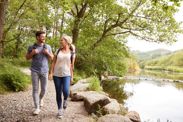 Man and Woman walking outside by stream small